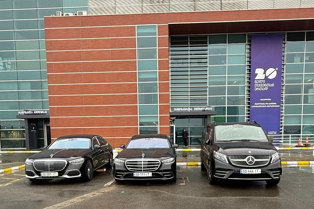 სამი შავი Mercedes — Maybach, S-Class და V-Class — გვერდიგვერდ გაჩერებული თბილისის საერთაშორისო აეროპორტის შემოსვლა-გასვლის წინ.